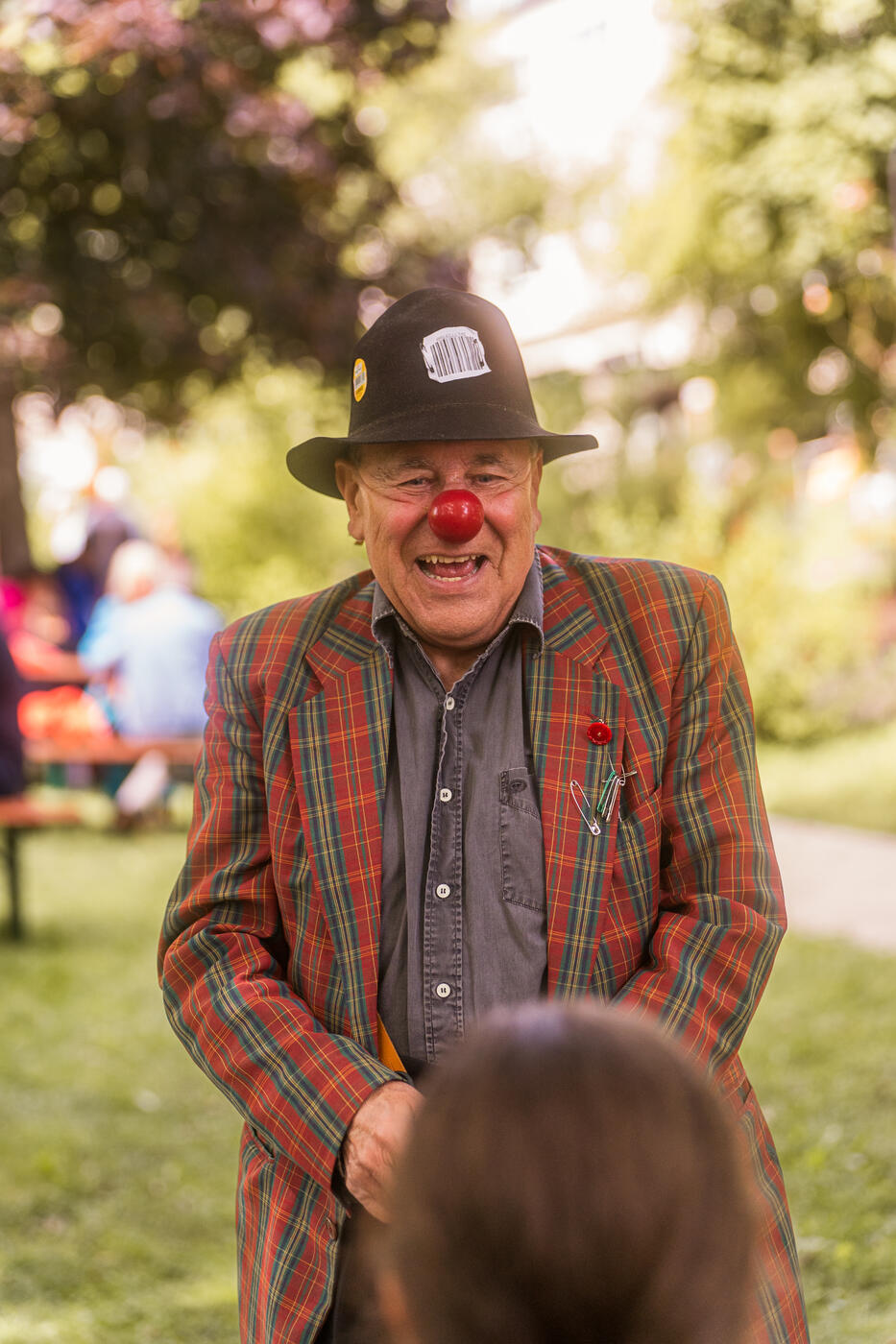 Ein Clown mit roter Nase unterhält ein Kind