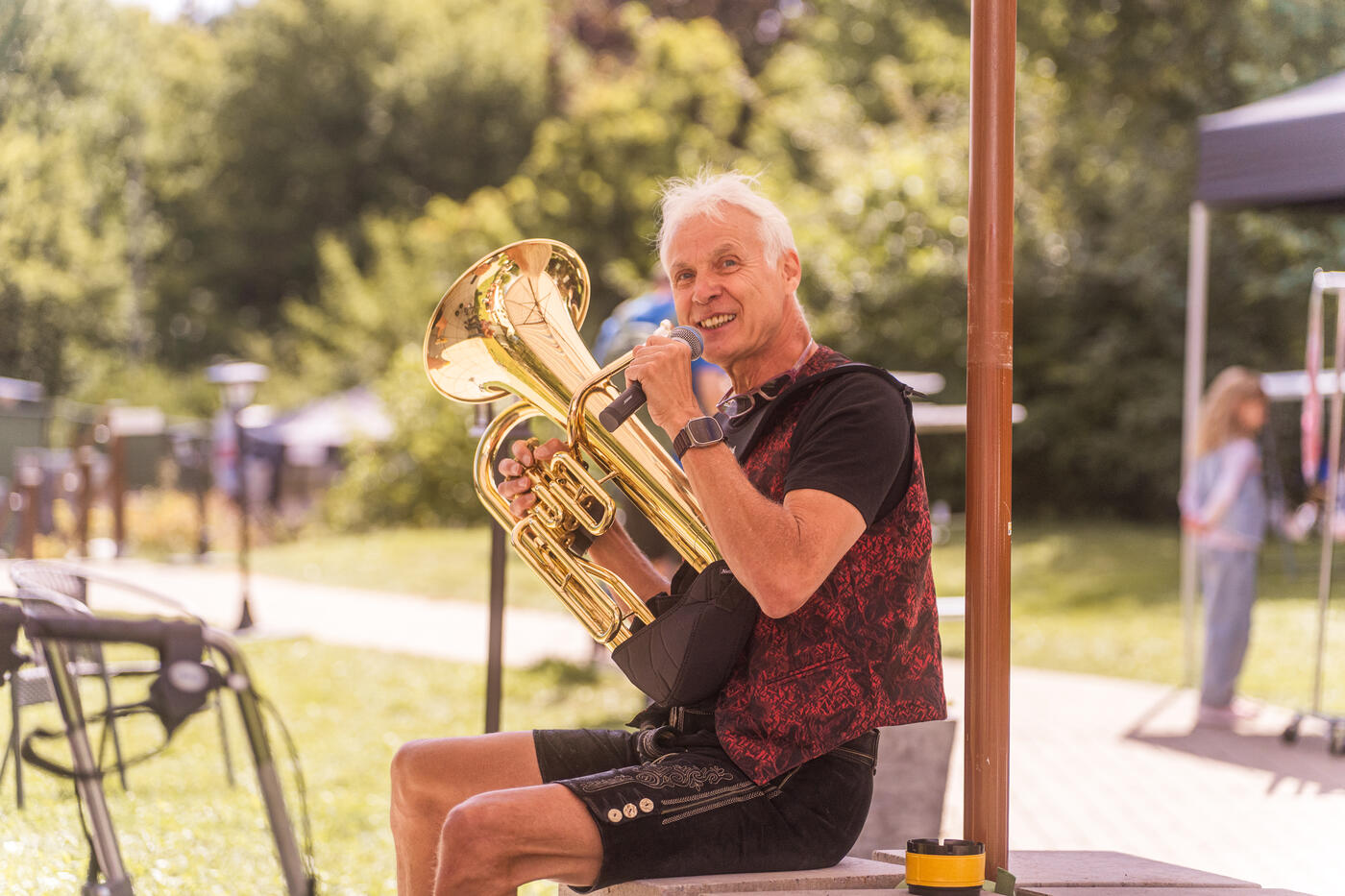 Musiker in Tracht spielt Tuba im Park