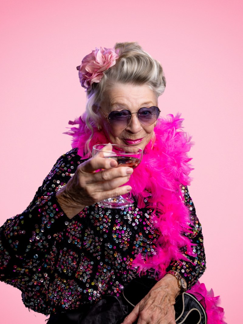 Fotoprojekt „Träume kennen kein Alter“ – Bewohnerin glamourös mit Federboa und Sektglas