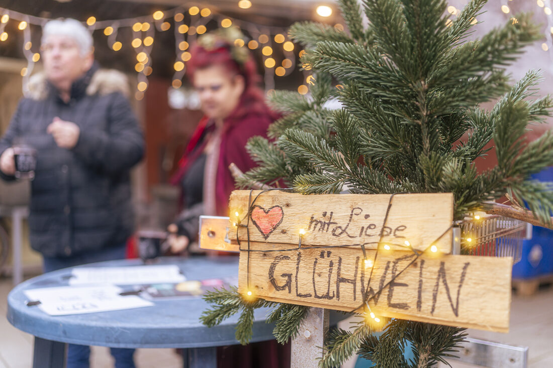 Marktstand mit Holzdeko und Lichterketten beim Winterwunderzauber