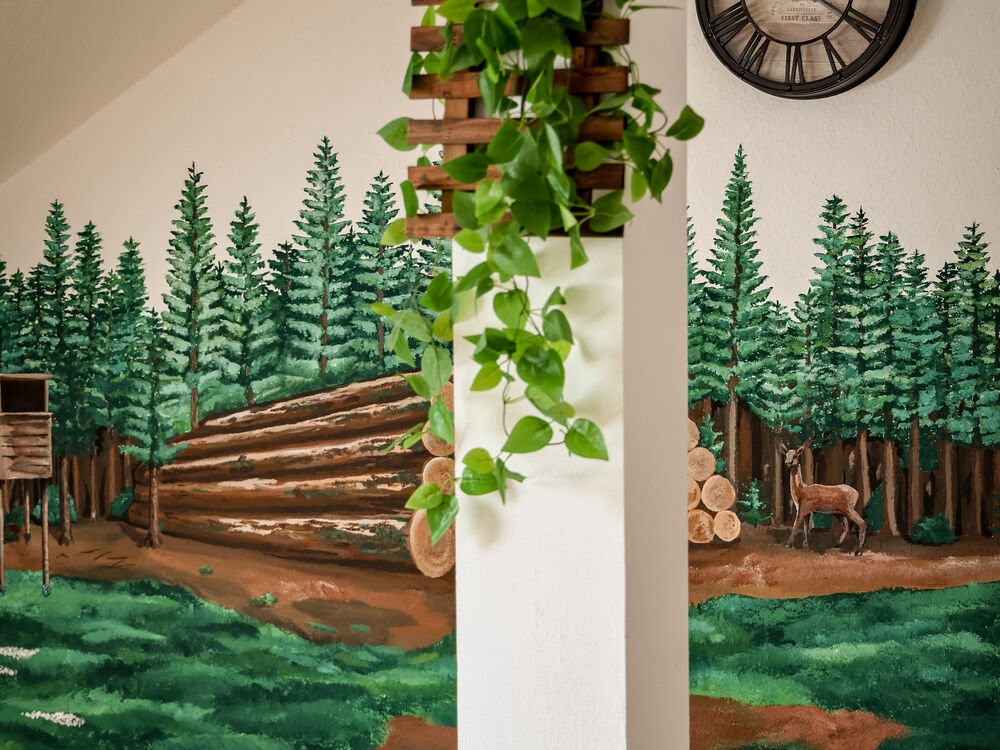 Wandmalerei mit Wald- und Baumstammmotiv im Flur des Wohnbereichs Holz