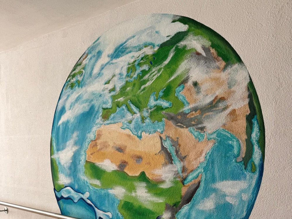 Wandmalerei einer Weltkugel im Flur des Wohnbereichs Wasser